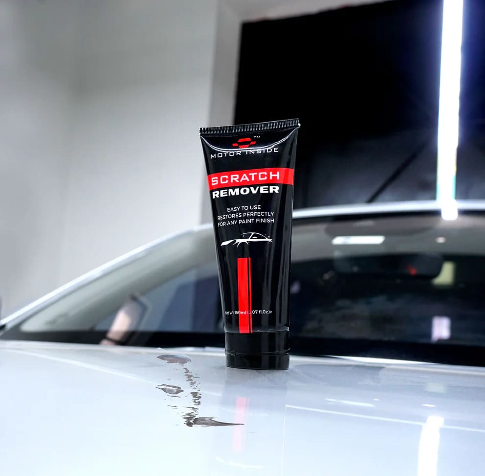 A tube of scratch remover placed on a car surface, showing visible scratches that can be removed using the product.