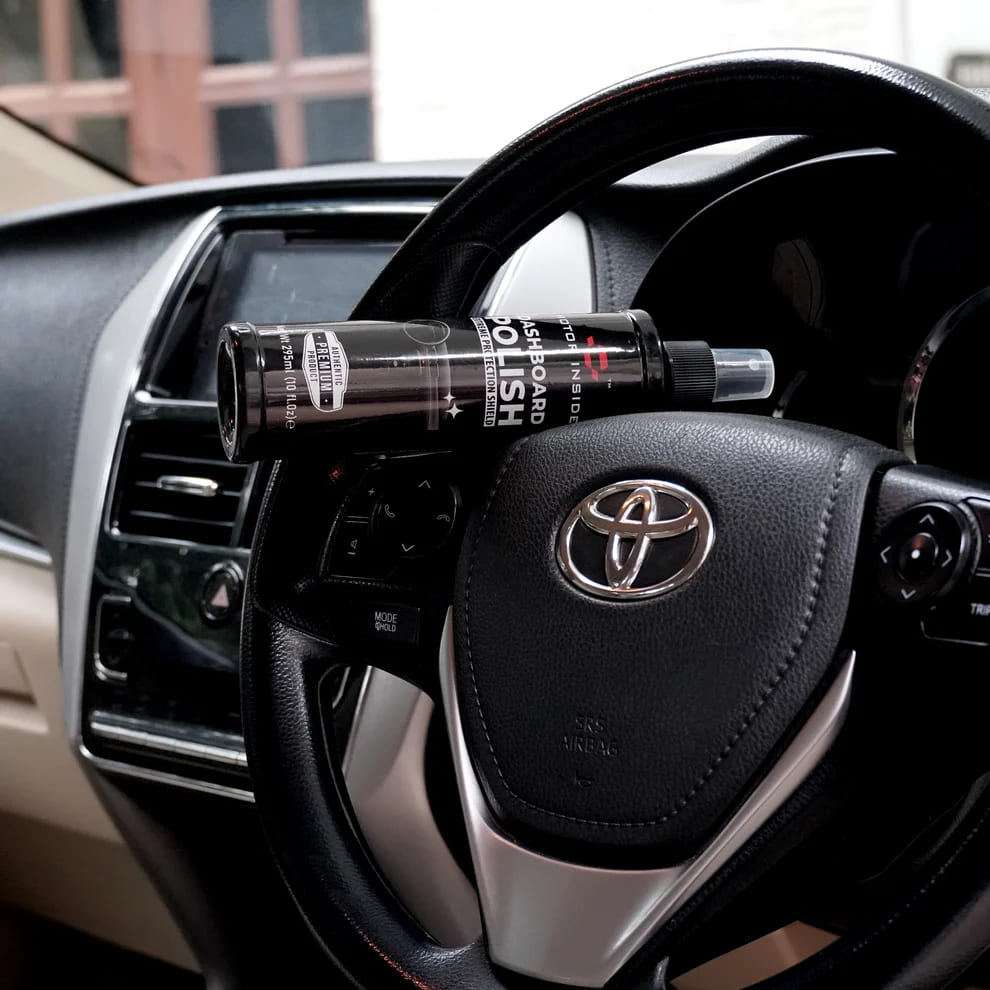 Car steering wheel with a bottle of Dashboard Polish on a Toyota vehicle