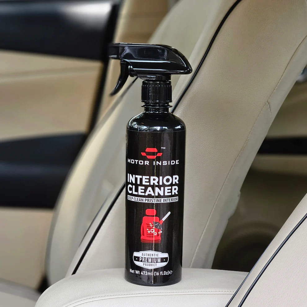 Black spray bottle of 'Motor Inside' interior cleaner on a car seat