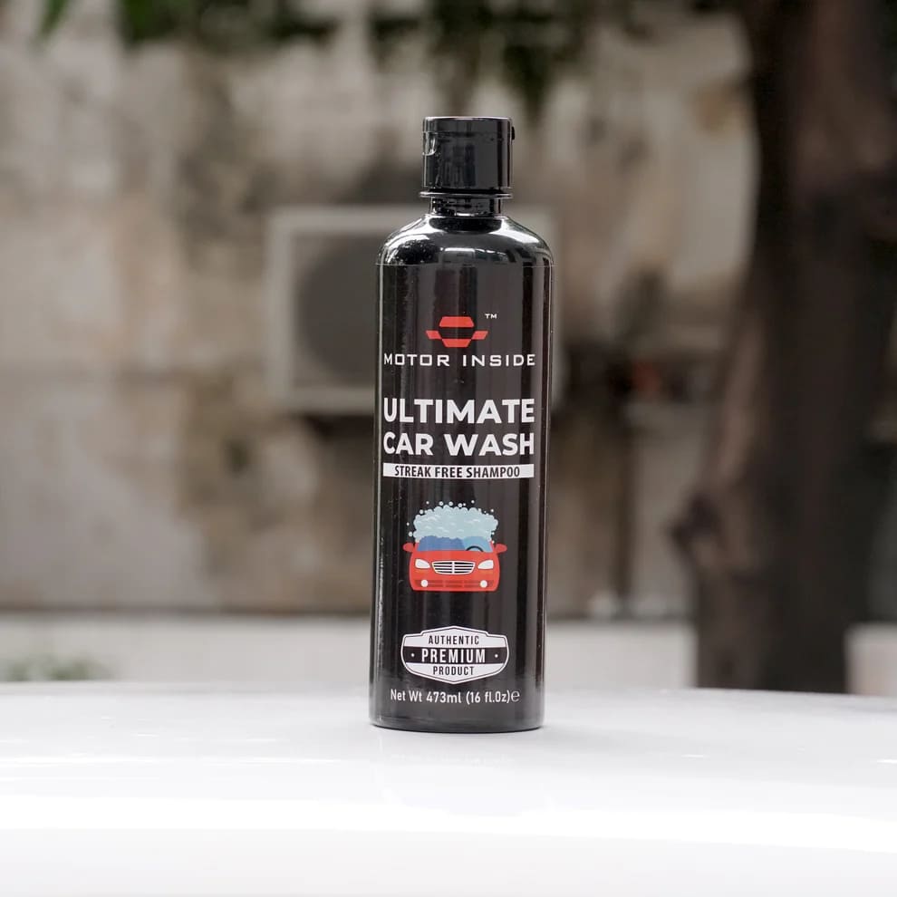 Bottle of 'Motor Inside Ultimate Car Wash' on a white surface with a blurred background